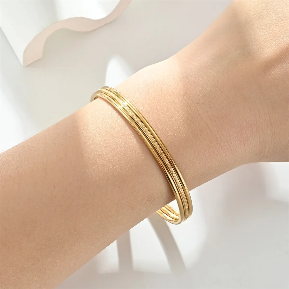 ゴールドアクセサリー 三重重ね巻き輝き加工バングル